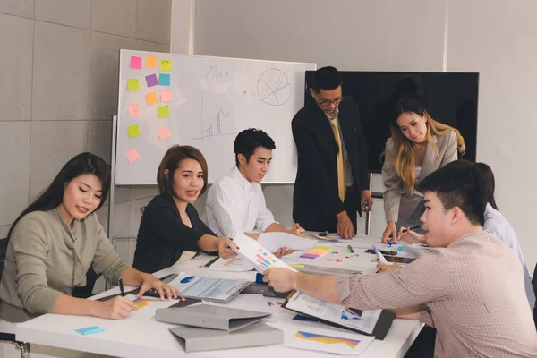 Bir grup Asyalı iş adamı işlerini tartışıyor.