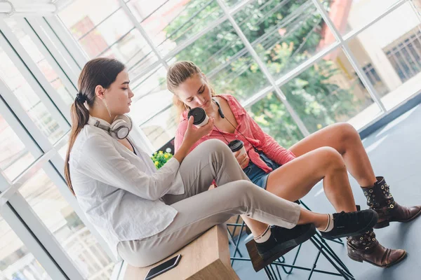 Two beautiful women sit talking. In the concept of relaxation.