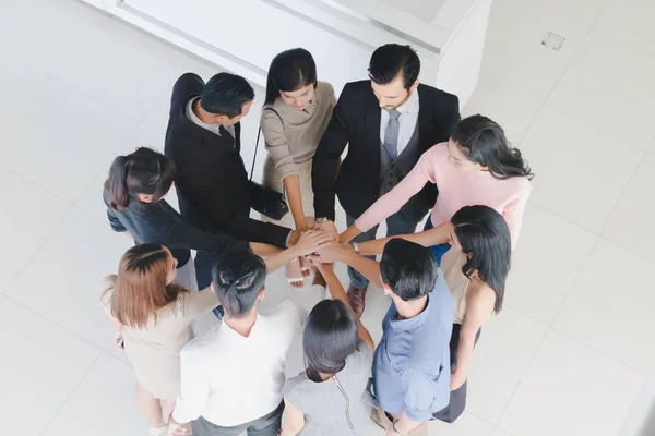 Male and female businessmen join hands in the hall of office.Top