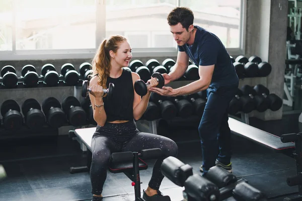 Güzel bir kadın egzersiz ve spor yapıyor. Antrenör veriyor.