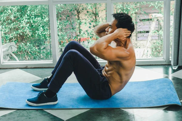 Asiáticos homens com belos músculos estão fazendo sit-ups — Fotografia de Stock