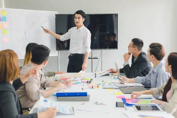 Sekelompok pengusaha Asia sedang berdiskusi. Karyawan adalah prese — Stok Foto