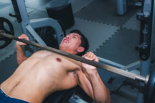 Asiatische muskulöse Männer stemmen Gewichte im Fitnessstudio. — Stockfoto