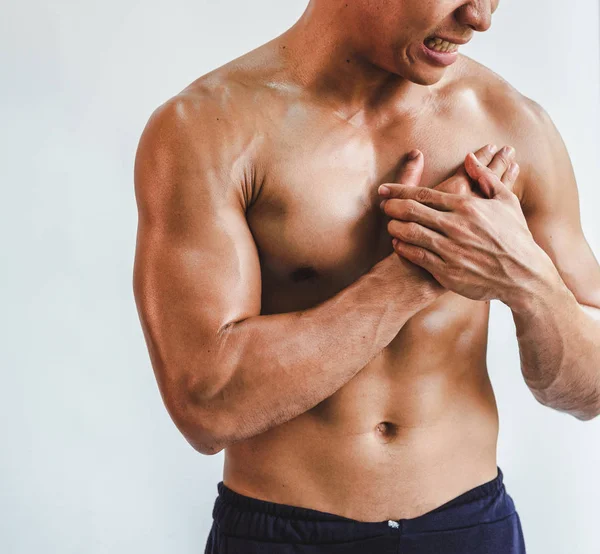 Asian man with muscular Injury to the chest from exercise on Whi — Stockfoto