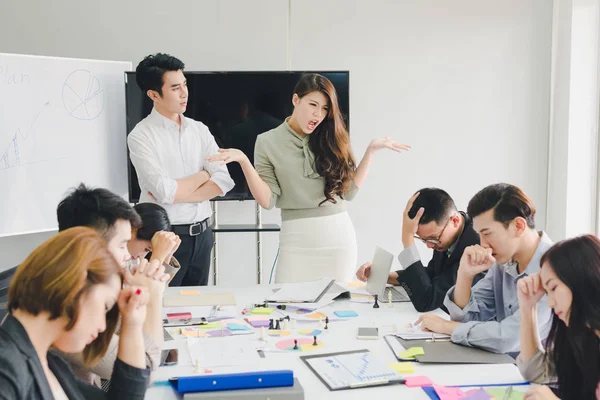 Bir grup Asyalı iş adamı tartışıyorlar. Çalışanlar ön plandadır.