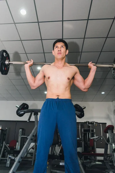 Asiatische muskulöse Männer stemmen Gewichte im Fitnessstudio. — Stockfoto