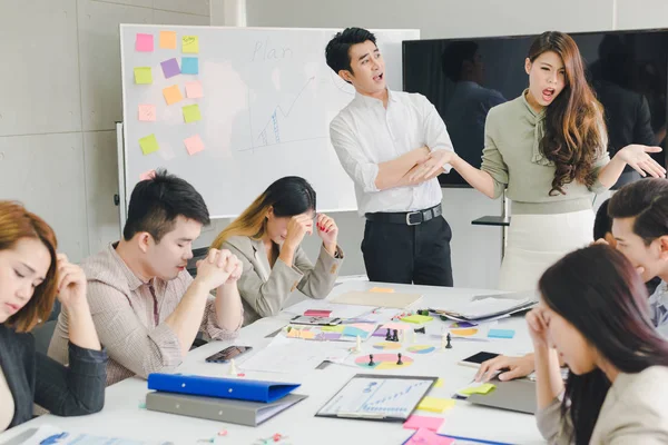 Bir grup Asyalı iş adamı tartışıyorlar. Çalışanlar ön plandadır.