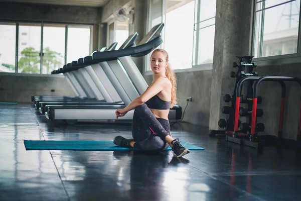 Güzel bir sporcu bir takım elbise giydi. Bir kas üzerinde gerinme
