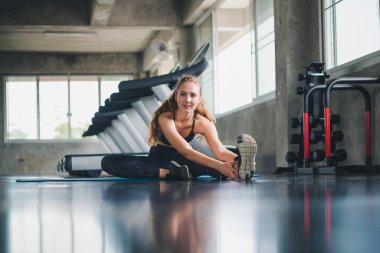 Güzel bir sporcu bir takım elbise giydi. Bir kas üzerinde gerinme