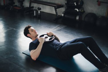 Young man caucasian was exercising by the use weight plate on yo