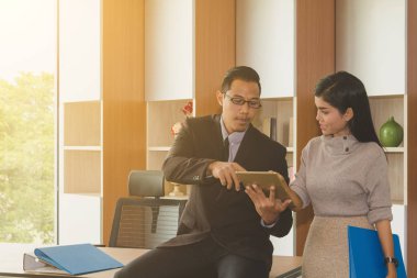 İş adamı ve sekreter ofiste iş konuşuyorlar..