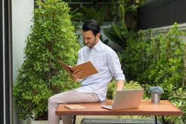 Bahçede çalışan genç adam.