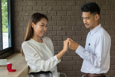 Asyalı genç adam kahveyle evlenmek için bir alyans kutusu tutuyor.