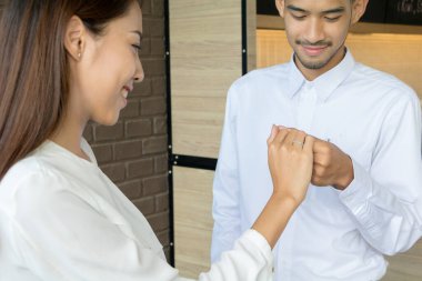 Asyalı genç adam kahveyle evlenmek için bir alyans kutusu tutuyor.