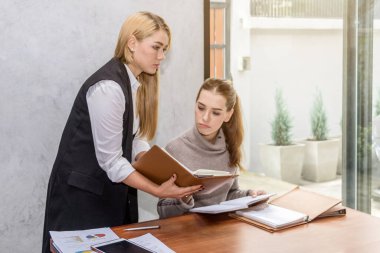 İki kadın okuyor ve öğretiyor. 