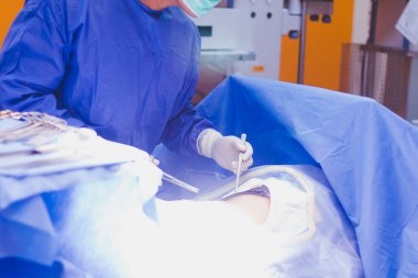 Cerrahi ekip ameliyathanedeki hastaya ameliyat yapıyor.