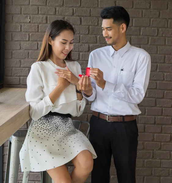 Asiático jovem segurar uma caixa de anel de casamento para se casar no café — Fotografia de Stock