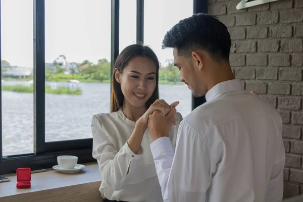 Asiático joven celebrar un anillo de boda caja para casarse en café — Foto de Stock