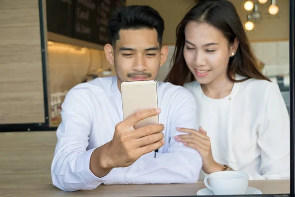 Asiatiska unga par förälskade på ett kafé — Stockfoto