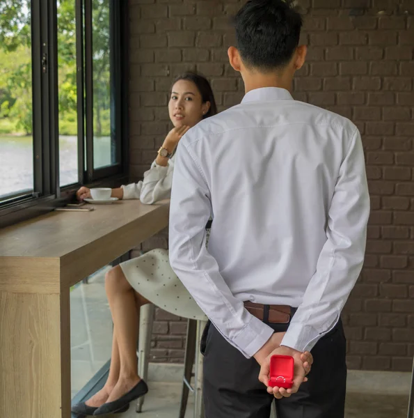 Asiático jovem segurar uma caixa de anel de casamento para se casar no café — Fotografia de Stock