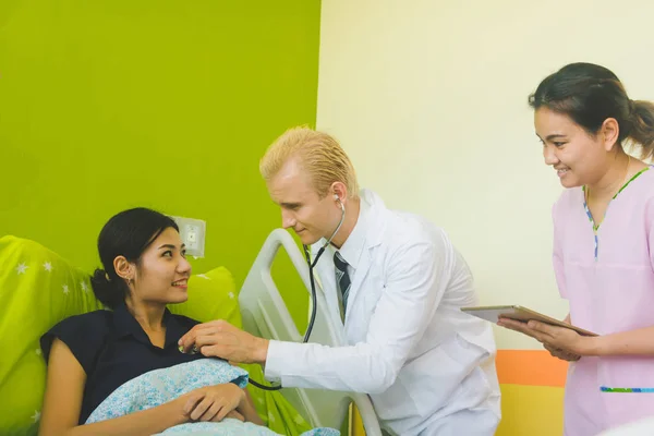 Médico y enfermera están escuchando el corazón mediante el uso de un sethoscop —  Fotos de Stock