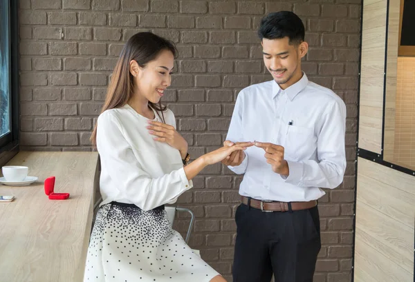 Asiático joven celebrar un anillo de boda caja para casarse en café — Foto de Stock