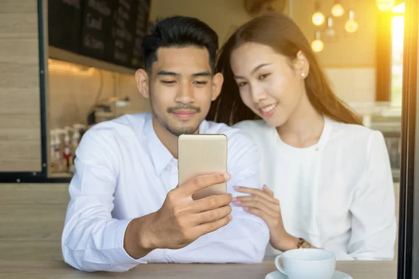 Asiatiska unga par förälskade på ett kafé — Stockfoto