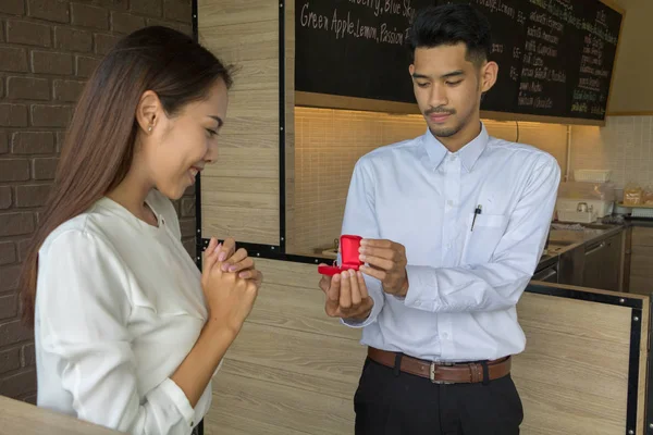 Asijské mladý muž držet snubní prsten box se oženit v kávě — Stock fotografie