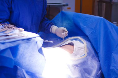Cerrahi ekip ameliyathanedeki hastaya ameliyat yapıyor.