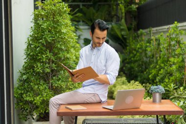 Bahçede çalışan genç adam.