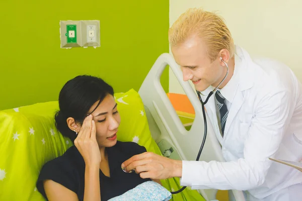 Médico y enfermera están escuchando el corazón mediante el uso de un sethoscop —  Fotos de Stock