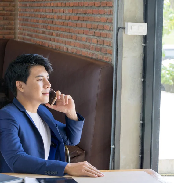 Hombre de negocios asiático leer cómodamente en una cafetería . — Foto de Stock