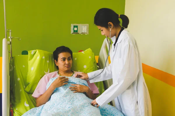 El médico está escuchando al corazón usando un sethoscope y exámenes —  Fotos de Stock