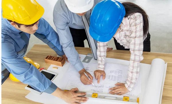 A group of engineers are looking at a blueprint for construction — Stock Photo, Image