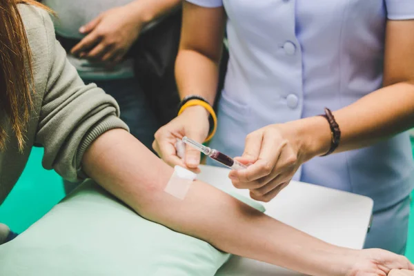 A enfermeira toma o sangue do paciente com uma seringa . — Fotografia de Stock