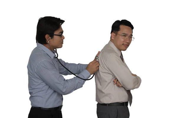 アジアの医者はビジネスマンを調べるために聴診器を使っている — ストック写真