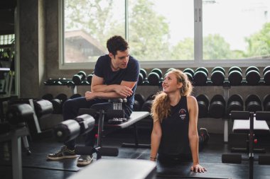 Spor eğitmeni genç bayan sporcuların eğitimini kontrol ediyor. Spor salonu konseptinde atlet fitness egzersizleri.