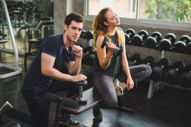 Spor eğitmeni genç bayan sporcuların eğitimini kontrol ediyor. Spor salonu konseptinde atlet fitness egzersizleri.