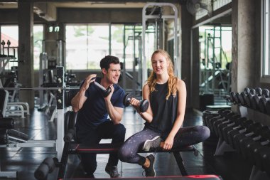 Spor eğitmeni genç bayan sporcuların eğitimini kontrol ediyor. Spor salonu konseptinde atlet fitness egzersizleri.