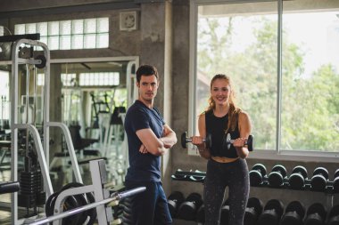 Spor eğitmeni genç bayan sporcuların eğitimini kontrol ediyor. Spor salonu konseptinde atlet fitness egzersizleri.