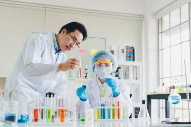 Asyalı bilim adamları, erkekler ve kadınlar birçok bilimsel ekipmana sahip laboratuvarlarda çeşitli renk kimyasallarının test ve analizine yardım ediyorlar..