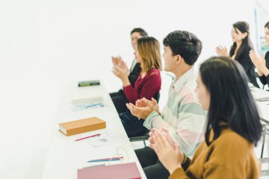 Asyalılar seminerlere katılır ve eğitim odasındaki hoparlörlerden ders dinlerler. Bazı insanlar not alır. Bazı insanlar anlatıcı sormak için ellerini kaldırdı. Ve konuşmacı konuşmasını bitirdiğinde alkışlandı..