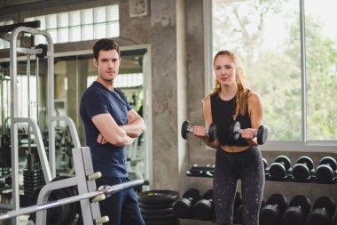 Spor eğitmeni genç bayan sporcuların eğitimini kontrol ediyor. Spor salonu konseptinde atlet fitness egzersizleri.