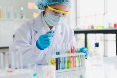 Asyalı bilim adamları laboratuvarda birçok kimyasalı test edip analiz ediyorlar. Bilim ve Kimyasal Konseptler.