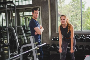 Spor eğitmeni genç bayan sporcuların eğitimini kontrol ediyor. Spor salonu konseptinde atlet fitness egzersizleri.