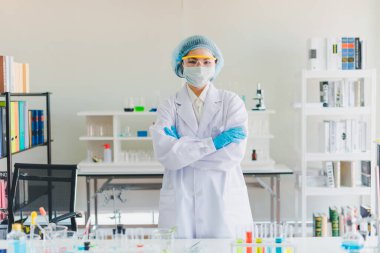 Asyalı bilim adamları laboratuvarda test ve analiz için kimyasallar hazırlıyorlar. Bilim adamları cam ve beyaz gömlekleri temizliyorlar. Bilim ve Kimya Konsepti