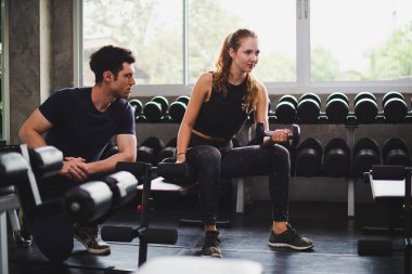 Spor eğitmeni genç bayan sporcuların eğitimini kontrol ediyor. Spor salonu konseptinde atlet fitness egzersizleri.