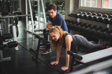 Spor eğitmeni genç bayan sporcuların eğitimini kontrol ediyor. Spor salonu konseptinde atlet fitness egzersizleri.