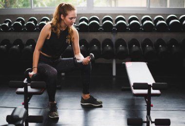 Spor eğitmeni genç bayan sporcuların eğitimini kontrol ediyor. Spor salonu konseptinde atlet fitness egzersizleri.