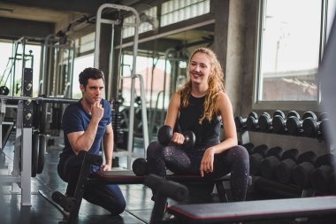 Spor eğitmeni genç bayan sporcuların eğitimini kontrol ediyor. Spor salonu konseptinde atlet fitness egzersizleri.